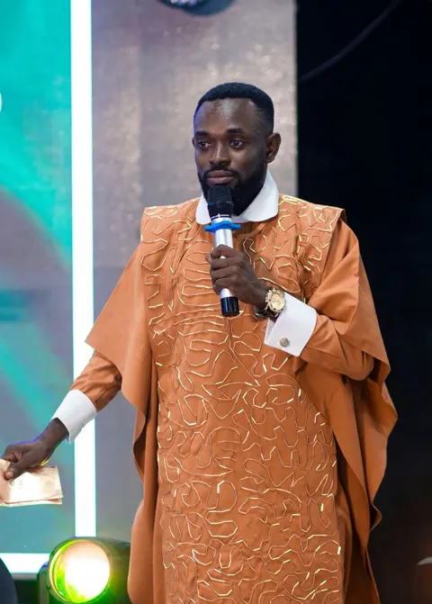 Pastor Joseph Kwabla Tetteh ministering on stage in traditional attire