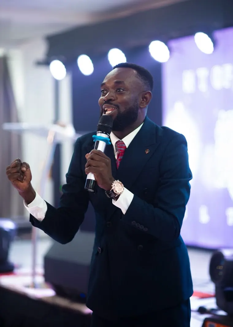 Pastor Joseph Kwabla Tetteh preaching with a microphone at a Ruach Filled service