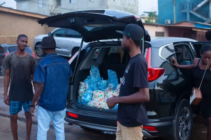 Members beside a car whose boot is full of food packs