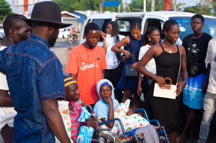 Ministry members gathered around two food-pack recipients in wheelchairs