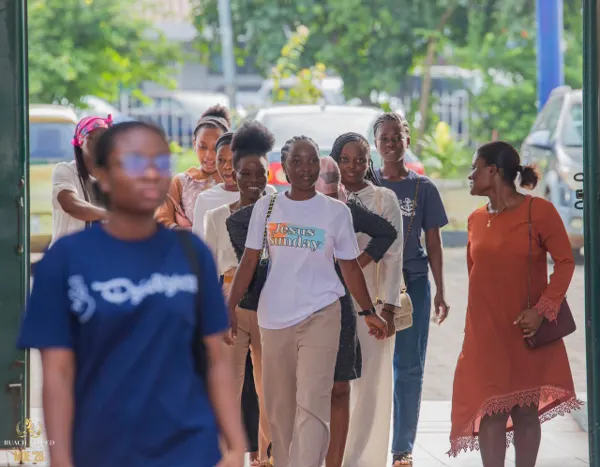 Smiling young women walking through the entrance gates to the conference